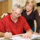 Mature couple in financial trouble is filling out a loan application.