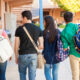 Rear view of a bunch of high school students walking down the hallway